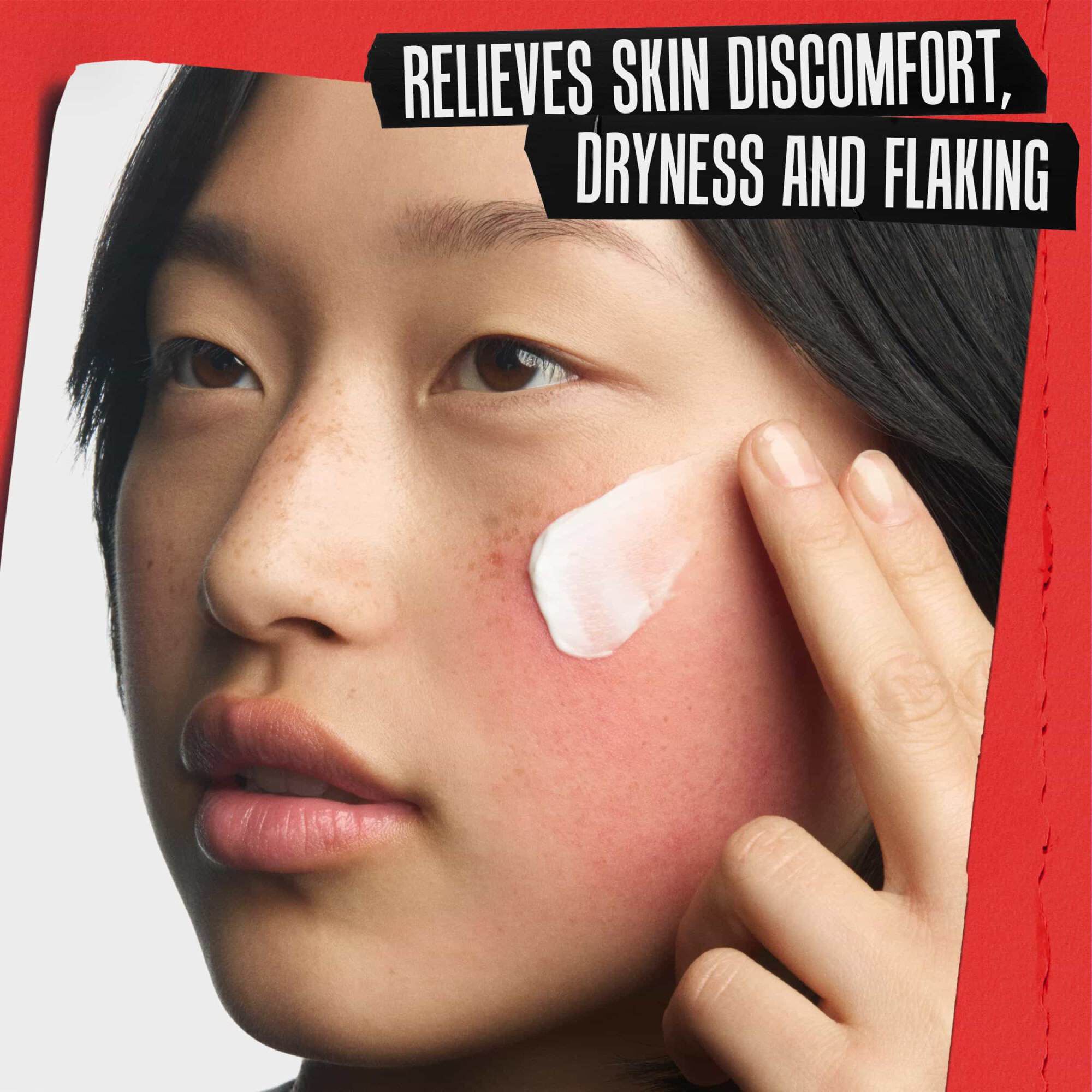 Близък план на възстановяващ крем, нанасян върху раздразнена буза. Текстът гласи: ОБЛЕКЧАВА ДИСКОМФОРТА, СУХОТАТА И ЛЮЩЕНЕТО НА КОЖАТА.