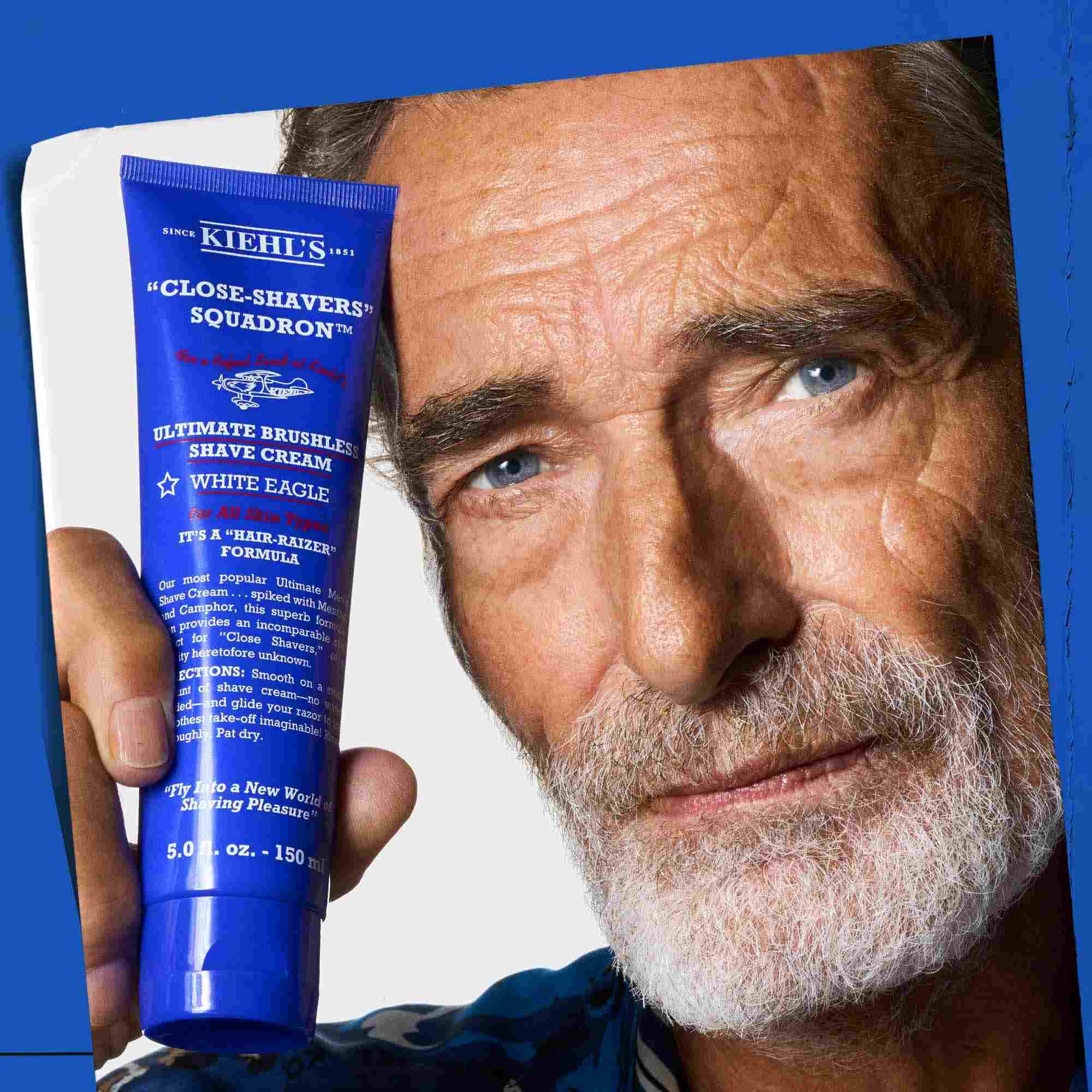 Мъж, държащ туба Ultimate Brushless Shave Cream White Eagle.