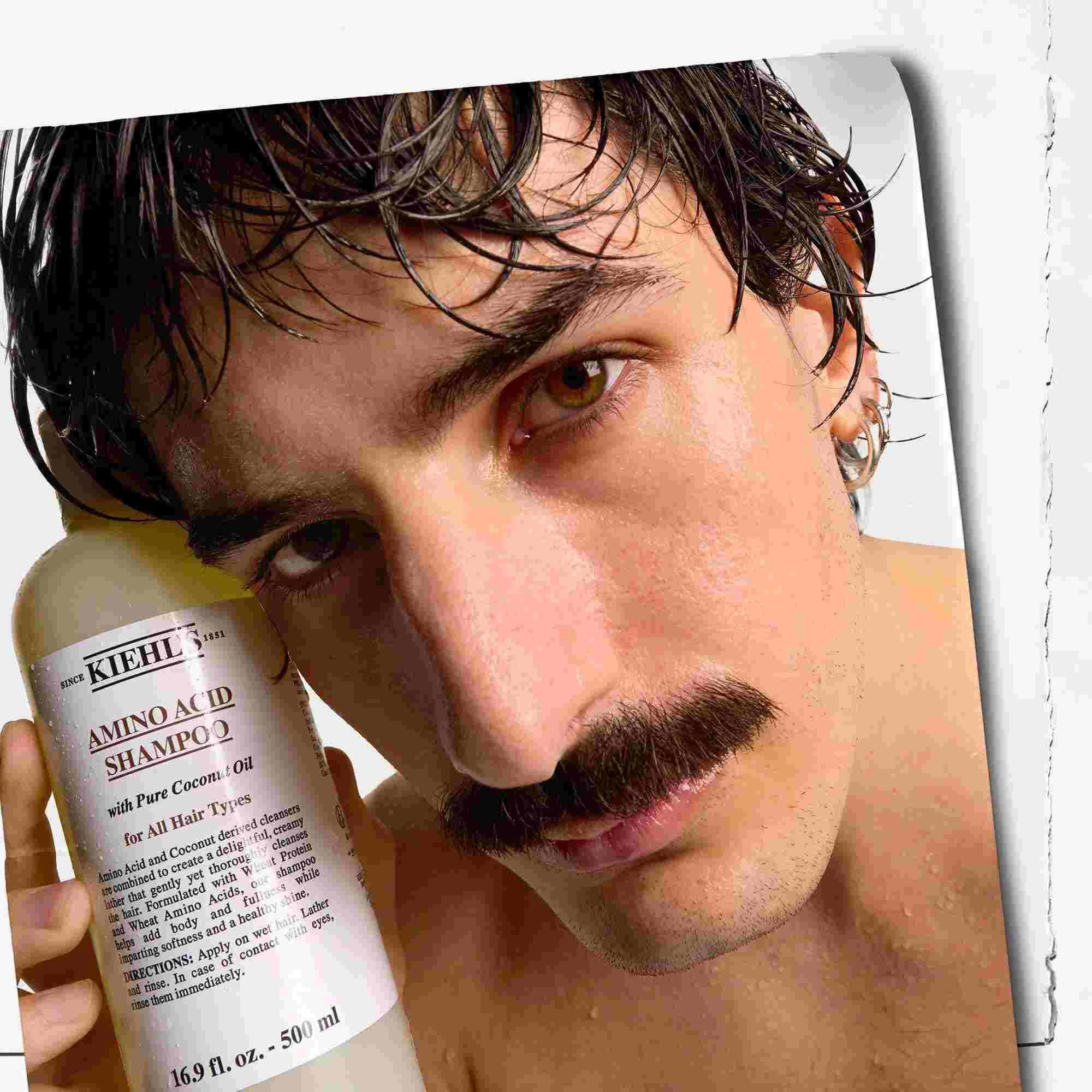Модел с мустаци и бутилка шампоан Kiehl's Amino Acid Shampoo