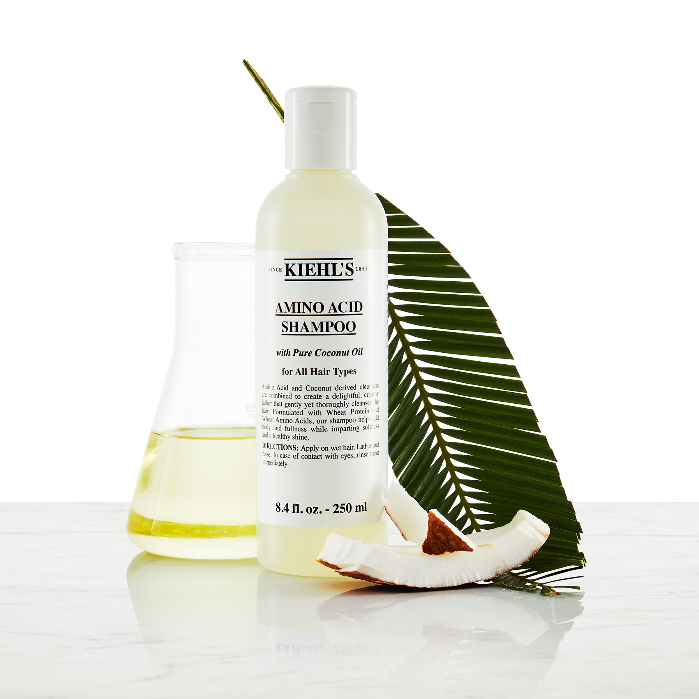 Модел с мустаци и бутилка шампоан Kiehl's Amino Acid Shampoo