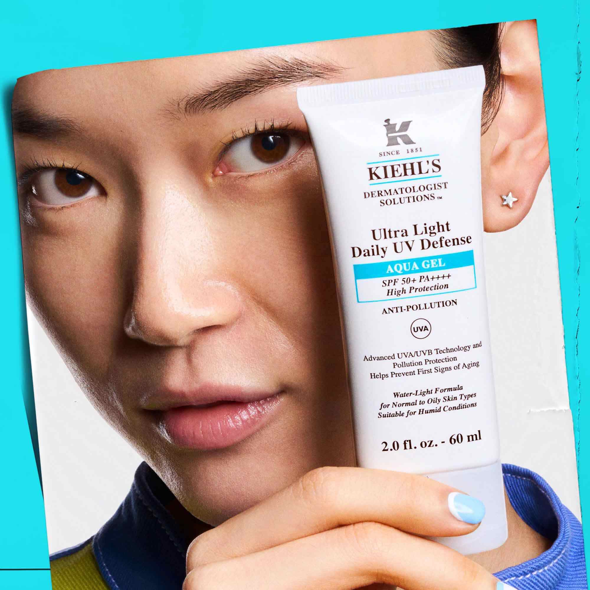 Модел, държащ туба Ultra Light Daily UV Defense Aqua Gel, показващ преносимостта и лекотата на употреба.