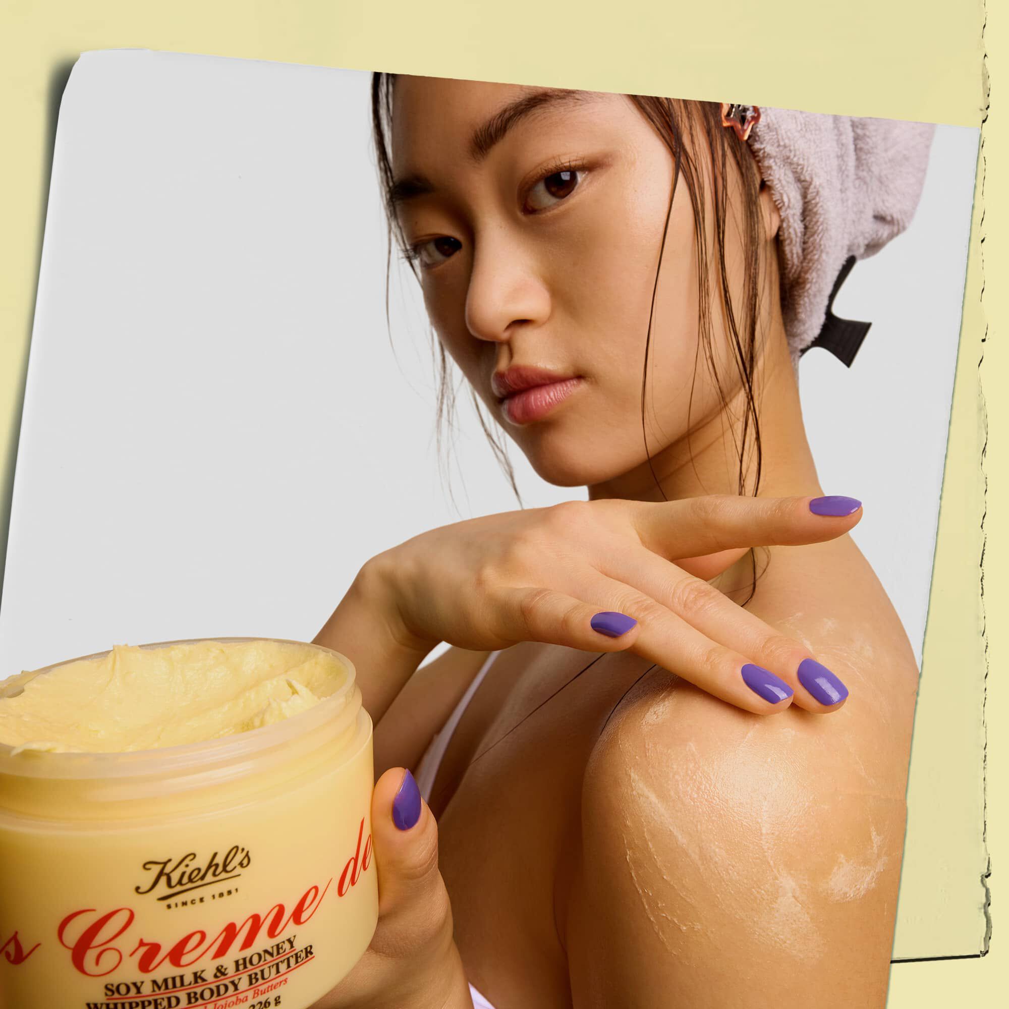Модел, държящ бурканче и нанасящ крем за тяло Kiehl's Creme de Corps Whipped Butter