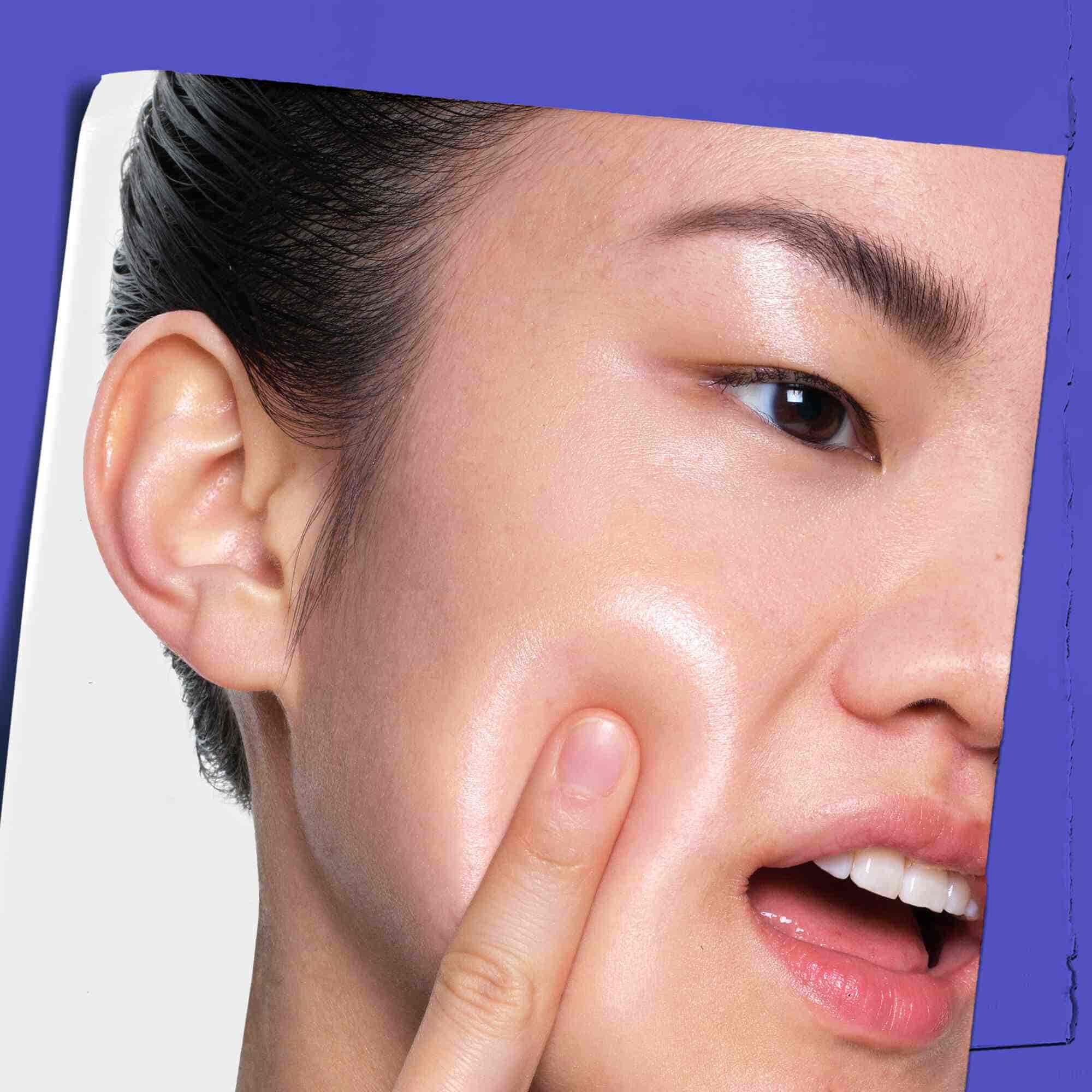 Човек, нанасящ Clearly Corrective Dark Spot Solution върху кожата си.