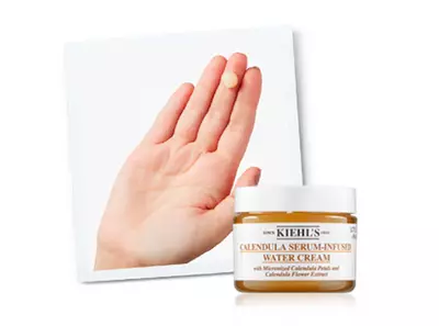 Крем с календула от Kiehl's, показан върху ръка, с акцент на текстурата и формулата му.