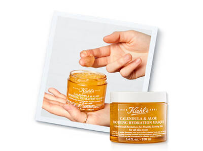 Ръка държи гел маска за хидратация на Kiehl's с календула и алое, пред фона на опаковката на продукта.