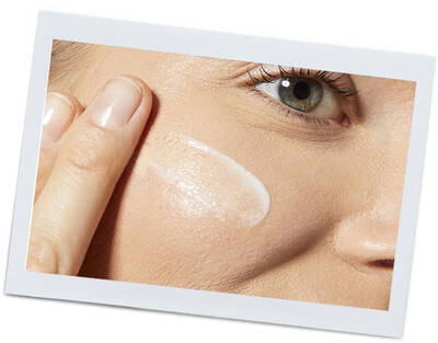 Жена нанася крем върху лицето си, показвайки ухажваща грижа за кожата.