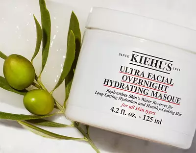 Крем за лице Kiehl's Ultra Facial Overnight Hydrating Masque в опаковка с маслинени клонки в съдържанието.
